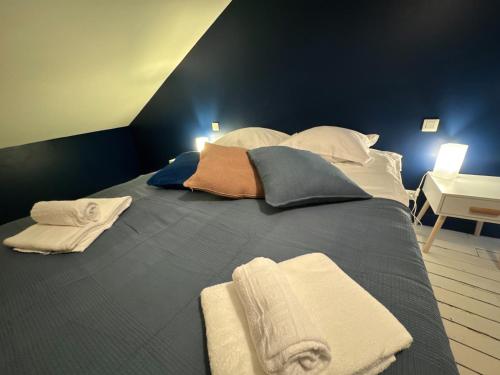 a large bed with towels and pillows on it at La Maison D'Oscar in Parthenay