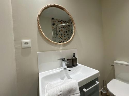 a bathroom with a sink and a mirror at La Maison D'Oscar in Parthenay