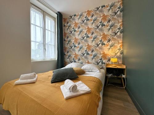 a bedroom with a bed with towels on it at La Maison D'Oscar in Parthenay
