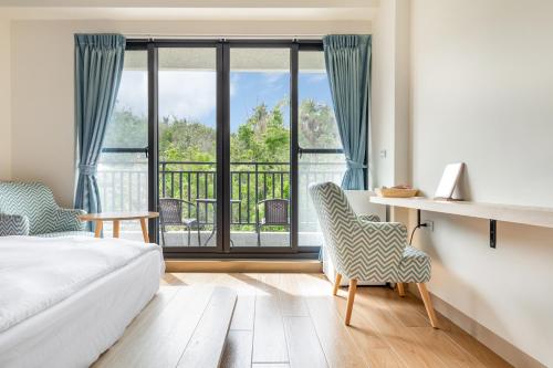 a bedroom with a bed and a view of a balcony at 北極熊旅店 in Xiaoliuqiu