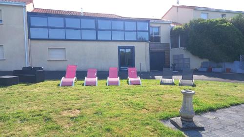 a group of pink chairs sitting in a yard at Gîte Chez Gwen et Flo avec Jardin in Cholet