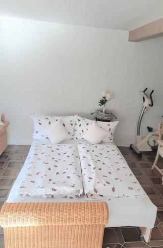 a bed with white sheets and pillows in a room at Apartment Rose in Forbach
