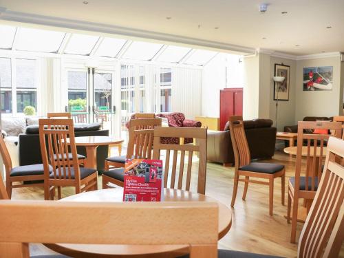 a room with tables and chairs and a living room at Pebble Path at Marine Court in Littlehampton