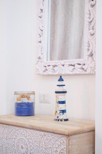 a mirror above a dresser with a lighthouse on it at Pharus Miseni Suites and rooms in Bacoli