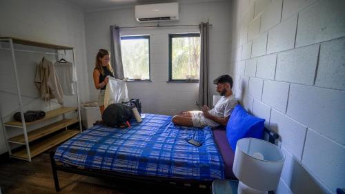 a man sitting on a bed in a room with a dog at Summer House Cairns in Cairns