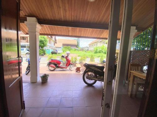 a motorcycle parked inside of a house with a porch at Luangprabang That Luang Boutique House in Luang Prabang