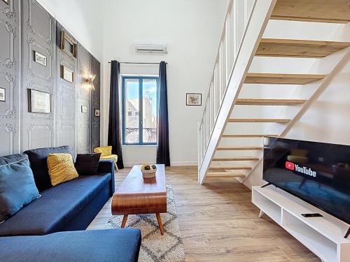 un salon avec un canapé bleu et un escalier dans l'établissement Le Datrio - Appartement proche des halles - Wifi et climatisation, à Narbonne