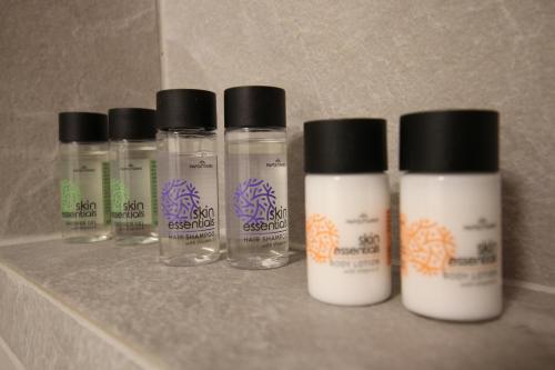a group of four bottles sitting on a shelf at Azure Haven in Hydra
