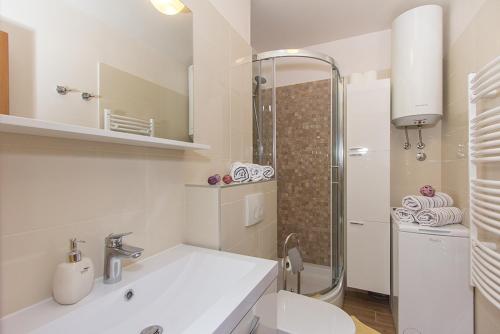 un bagno bianco con lavandino e doccia di Apartment Luce a Spalato (Split)
