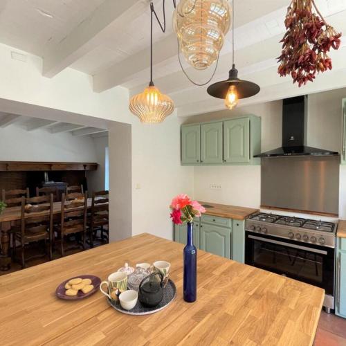 a kitchen with a wooden table with a vase of flowers on it at Gite Des Cimes in Baigts-de-Béarn