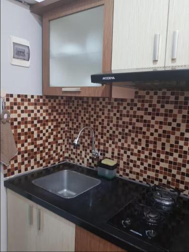 a kitchen with a sink and a counter top at Jardin B20, Pool View, Netflix & WIFI in Bandung