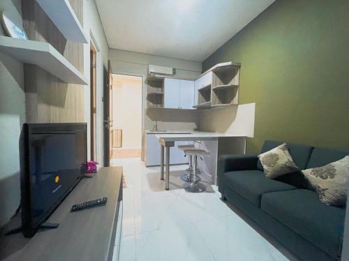 a living room with a couch and a tv and a desk at Sighma Palem Merah Senopati in Jakarta