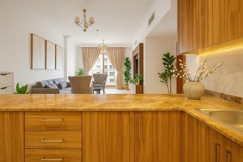 a kitchen with a sink and a living room at New Luxe 2 BR in Dubai