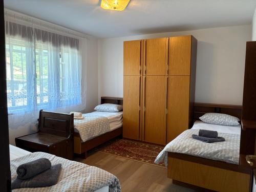 a bedroom with three beds and a cabinet and a window at Suzi Apartments in Lokev