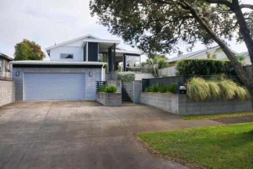 a house with a garage and a driveway at Relax on Richmond - modern beachside house retreat in New Plymouth