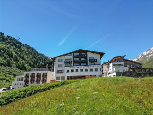a building on top of a hill in the mountains at Hotel Olympia in Obergurgl