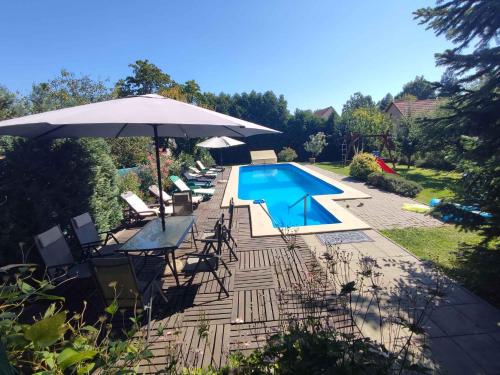 a swimming pool with chairs and an umbrella and a swimming pool at Apartments in Balatonföldvar 45318 in Balatonföldvár