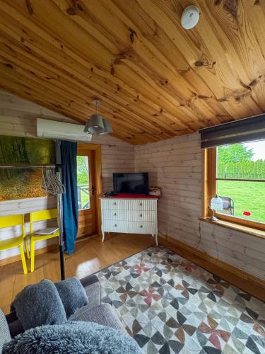 a living room with a couch and a tv at Goldingen Stone Retreat - Hot Tub and Nature in Kuldīga