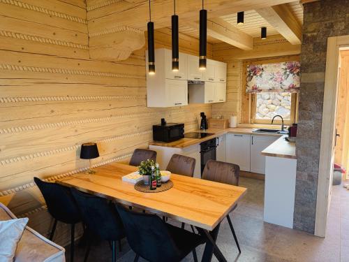 a kitchen and dining room with a wooden ceiling at Świerkowe Chatki w Koniakowie in Koniaków