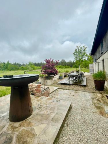 a stone patio with a table and a picnic table at Månpalatset in Lärbro