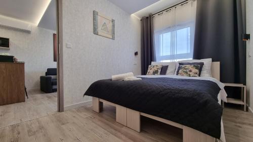 a bedroom with a bed with a large window at Q Apart PL 2 lub 3 pokojowe klimatyzowane apartamenty przy Manufakturze z garażem Gratis, FV in Łódź