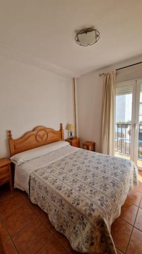 a bedroom with a bed and a large window at La Casa del Senderista in Arroyo Frio