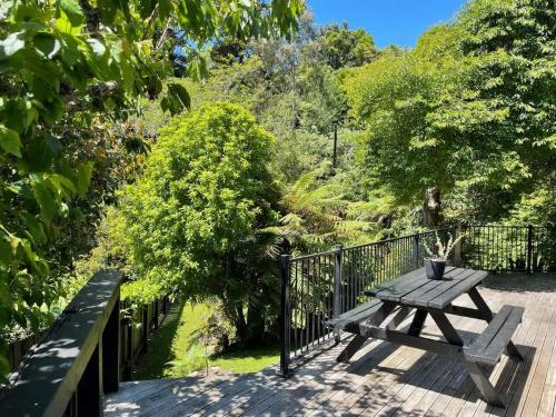 a wooden picnic table sitting on a wooden deck at Huatoki Hideaway Peaceful Central Location in New Plymouth