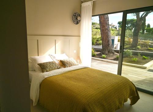 une chambre avec un lit et une grande fenêtre dans l'établissement Villa Boucharel, grande piscine, à 10 min à pied de la plage, à Roquebrune-sur Argens