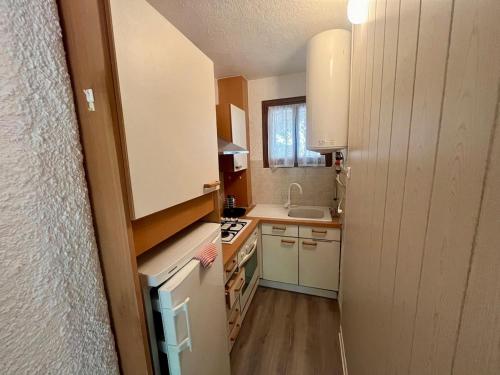 une petite cuisine avec un évier et une cuisinière dans l'établissement T2 avec jardin 100m de la mer, à Argelès-sur-Mer