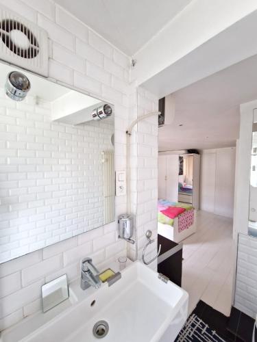 une salle de bain blanche avec un lavabo et un miroir dans l'établissement Marais Design flat, à Paris