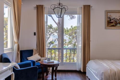 a hotel room with a bed and a window at TTR Joy Apart' Hotel in Da Lat