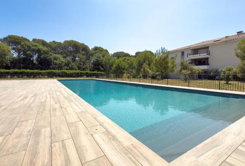 une piscine avec parquet et un bâtiment dans l'établissement appartement chic LA LONDE LES MAURES, à La Londe-les-Maures