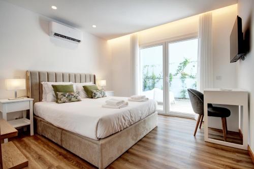 a bedroom with a bed and a desk and a window at Blue Hotel Oporto in Porto