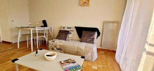 un salon avec un canapé et une table dans l'établissement Bleues Marines studio piscine, à Antibes