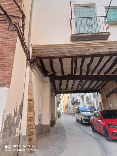 a building with awning over a street with parked cars at Apartamento Benabarre Huesca in Benabarre