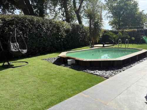 - une petite piscine dans une cour avec gazon dans l'établissement La Villa Détente, à Saint-Vincent-de-Tyrosse