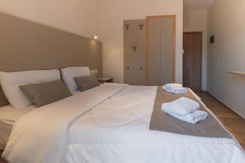 a large white bed with towels on top of it at Hotel Kaikis in Kalabaka
