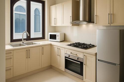 a kitchen with white cabinets and a sink and a microwave at Stay Smart, Stay Central in Male City