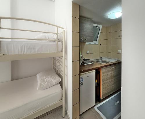 a small room with two bunk beds and a sink at MELI Studios by SDR in Paralia Katerinis