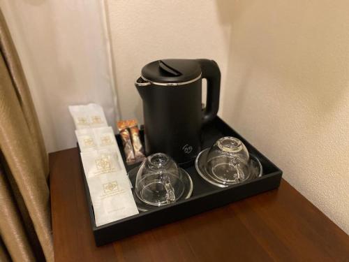 a tea pot and glasses on a tray on a table at Onson De Boutique Hotel in Luang Prabang