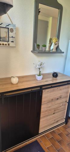 阿格德角Green Village, Maison climatisée, 6 pers, piscine, wifi, garage, terrasse的木制柜台上放着镜子和鲜花