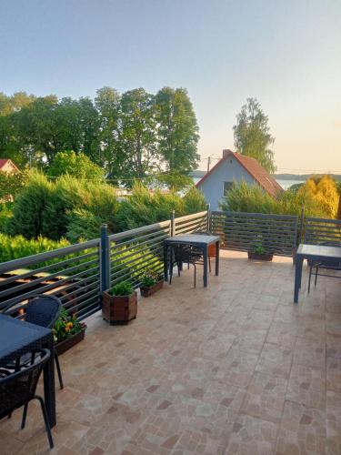 a patio with tables and benches and a fence at Stary Drahim in Czaplinek