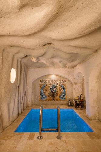 a swimming pool in a cave with a stone wall at Cappadocia Cave Suites Adult Only in Goreme