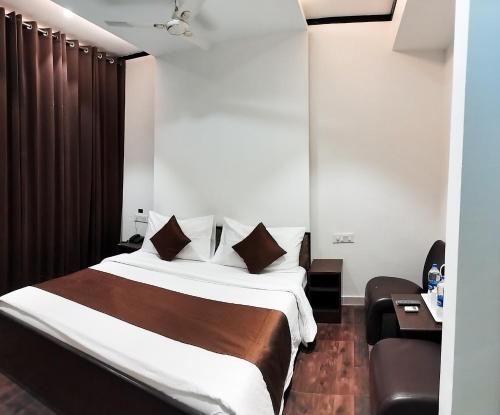 a hotel room with a bed and a chair at The Wind Cross in Kālka