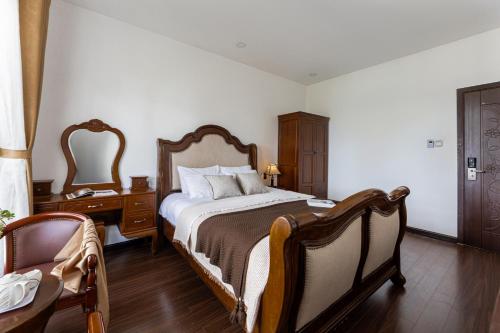 a bedroom with a bed and a table and a chair at TTR Joy Apart' Hotel in Da Lat