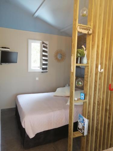 - une chambre avec un lit et une échelle en bois dans l'établissement Studio de charme à 300 m de la Plage de Santa Giulia, à Porto-Vecchio