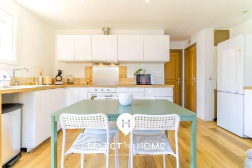 une cuisine avec une table verte et des placards blancs dans l'établissement SELECT'soHOME - Jolie maison pour 6 personnes avec jardin - MAISON OASIS, à Bormes-les-Mimosas