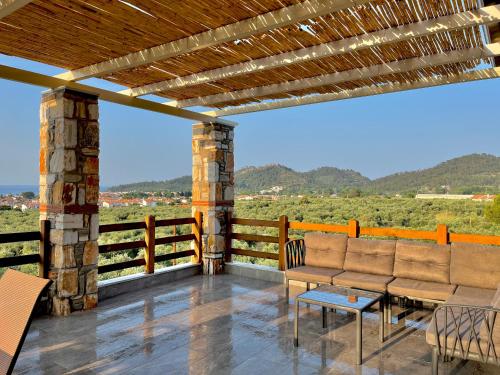 a patio with chairs and a table and a fence at Helicon Luxury Villas in Limenas