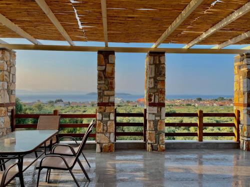 a patio with a table and chairs and a view at Helicon Luxury Villas in Limenas