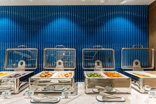 a bunch of food in trays on a table at Atour Hotel Suzhou University Town Yuexi Subway Station in Suzhou
